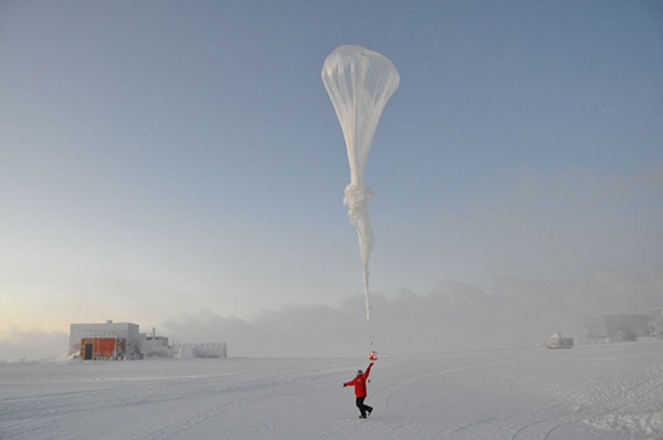 NOAA researchers at the South Pole release a ballonsonde, a massive balloon carrying instruments that measure ozone, temperature, humidity and more from the surface of the snow to about 20 miles high. (Credit: NOAA)